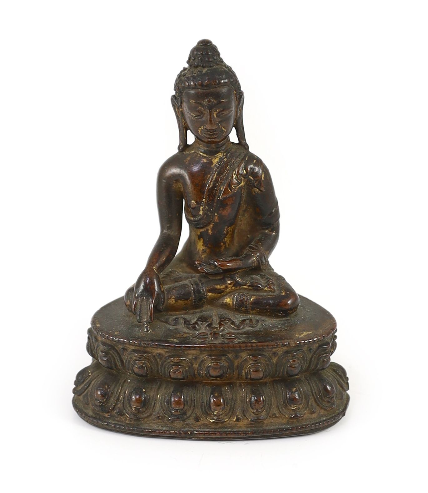 A small Tibetan gilt copper alloy seated figure of Buddha Shakyamuni, probably 15th/16th century, 10.4cm